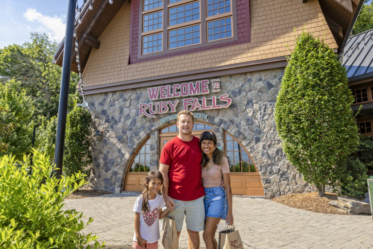 Parents and young daughter stand outside the entrance to Ruby Falls