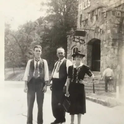 image of two men and one women standing near stone castle at Ruby Falls in the 1940s. 