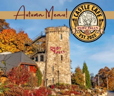 Limestone tower at Ruby Falls surrounded by trees with yellow, gold and red fall foliage 